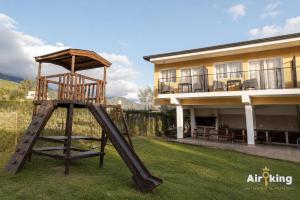 a swing set in a yard in front of a house at Suites Amplias y Comfortables - Con Balcon, Parquizado, Asador y Pileta in Tafí del Valle