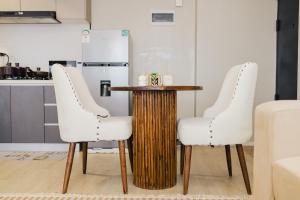 two white chairs around a wooden table in a kitchen at Everlett Lavington Homes in Nairobi