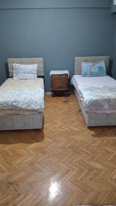 two beds in a room with a wooden floor at Huzur 30 in Edirne