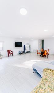 a white room with a bed and a tv at Casa Las Dunas in Monte Hermoso