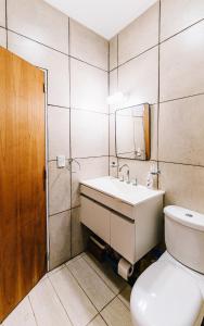 a bathroom with a toilet and a sink and a mirror at Casa Las Dunas in Monte Hermoso +6 photos