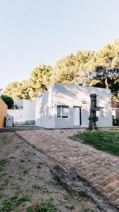 a white building with a mountain in the background at Casa Las Dunas in Monte Hermoso