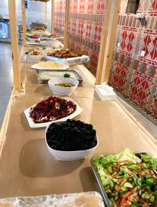 a buffet line with bowls of food on a table at Wadi Rum Elara Luxury Camp in Wadi Rum +9 photos