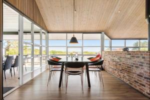 a dining room with a table and chairs and a brick wall at 8585-Glesborg-Tangvej-33 in Glesborg