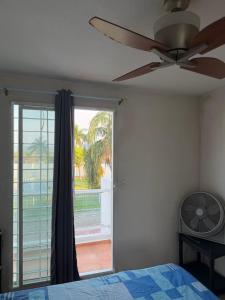 a bedroom with a ceiling fan and a window at Casa privada, alberca, jacuzzi y asador Teques in Jojutla +27 photos