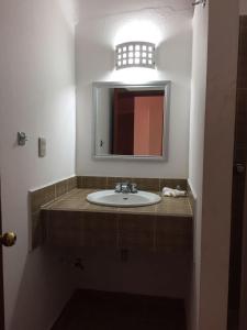 bagno con lavandino e specchio di Hotel Rivera a Città di Oaxaca