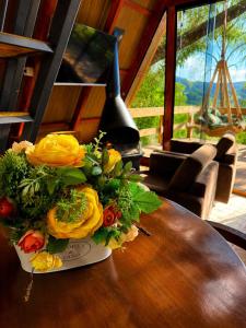 a vase of flowers on a table in a room at Cabana Fé in Nonoai
