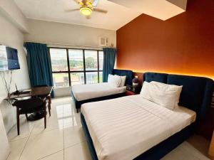 ein Hotelzimmer mit zwei Betten und einem Schreibtisch in der Unterkunft Pacific Park Hotel in Manila + 58 Fotos