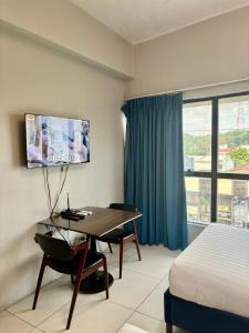 ein Hotelzimmer mit Schreibtisch und Bett in der Unterkunft Pacific Park Hotel in Manila