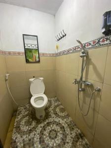 a bathroom with a toilet and a shower at JavaLO Lite in Lombok International Airport