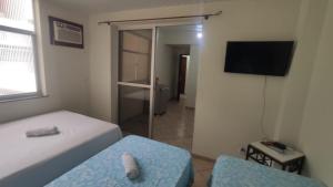 a bedroom with a bed and a chair and a television at Pousada Requinte in Vila Velha +92 photos