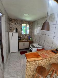 a kitchen with a refrigerator and a table and chairs at Aconchego Ebenézer in Praia de Provetá 