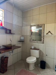 a bathroom with a toilet and a mirror at Aconchego Ebenézer in Praia de Provetá  +33 photos