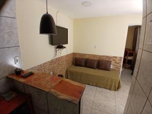 a living room with a bed and a tv at Aconchego Ebenézer in Praia de Provetá 