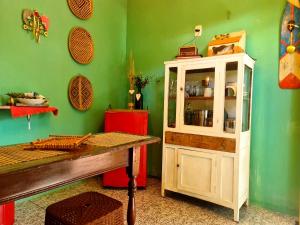 a green room with a white cabinet and a table at Casinha Aconchegante em Alter do Chão 2min da ilha in Alter do Chao
