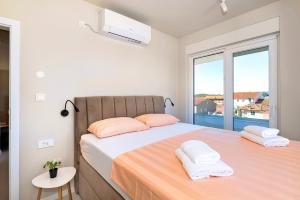 a bedroom with two beds and a large window at Providenca Residence Šibenik in Šibenik