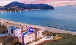 a view of a beach with a hotel and the ocean at Geoje Wave Hotel & Pension in Geoje