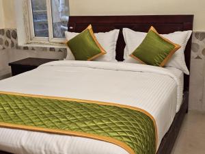 a large bed with green and white sheets and pillows at SAAI Rosorts iin Yercaud in Yercaud +1 photo