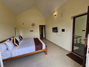 a bedroom with a bed and a sliding glass door at SAAI Rosorts iin Yercaud in Yercaud