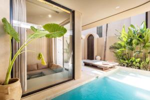 a villa with a swimming pool and a living room at SISI Wellness Villas in Bingin Beach