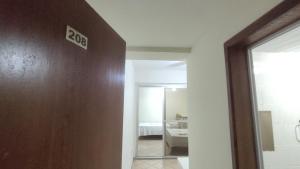 a bathroom with a door with a sign on it at Pousada Requinte in Vila Velha