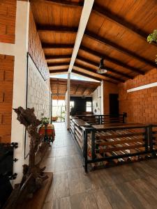 a large room with wooden ceilings and a brick wall at La Cabaña Mr Brown in Puerto Leguízamo