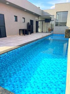 a large blue swimming pool next to a building at Casa de hospedagem e lazer in Sao Jose do Rio Preto