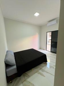 a bedroom with a black bed in a room at Casa de hospedagem e lazer in Sao Jose do Rio Preto +23 photos