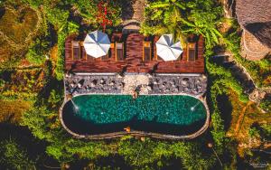 an overhead view of a house with a pool and umbrellas at Penida Bambu Green Suites in Nusa Penida