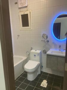 a bathroom with a toilet and a tub and a sink at فندق ميراب الروضة in Al Khansāk