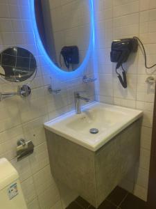 a bathroom with a sink and a mirror and a phone at فندق ميراب الروضة in Al Khansāk +2 photos