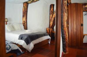 a bedroom with a bed with a wooden frame at San Pedro in Ráquira