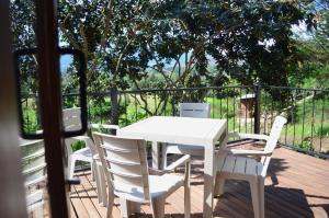 a white table and chairs on a wooden deck at San Pedro in Ráquira
