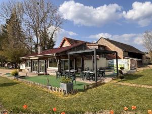 a house with a table and chairs in a yard at Les sarrays Golf et Lodges in Neuvy-Pailloux +23 photos