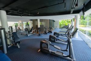 a gym with a row of treadmills and machines at Deluxe Studio-Condo at Tambuli Seaside Living in Maribago