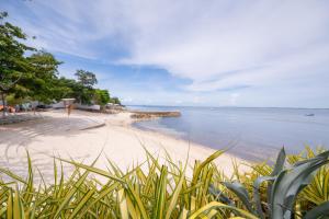 a sandy beach with a view of the ocean at Deluxe Studio-Condo at Tambuli Seaside Living in Maribago