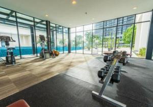a gym with cardio machines and a swimming pool at Trefoil Studio Unit Near Setia City Mall 1-5 Pax in Shah Alam