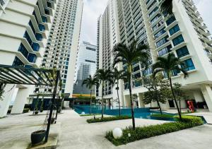 a courtyard with palm trees and tall buildings at Trefoil Studio Unit Near Setia City Mall 1-5 Pax in Shah Alam