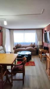 a living room with a couch and a table at DEPARTAMENTOS TERMAS DE CHILLAN in Nevados de Chillan