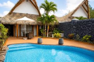 a villa with a swimming pool in front of a house at Aitutaki Escape Resort & Spa in Arutanga +12 photos