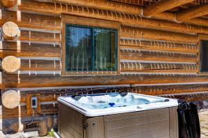 a hot tub in the corner of a log cabin at Adams Rest Cabin in The Dalles