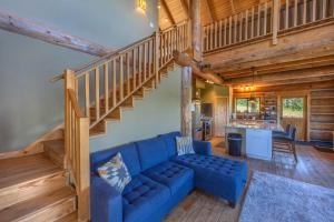 a living room with a blue couch and a staircase at Adams Rest Cabin in The Dalles