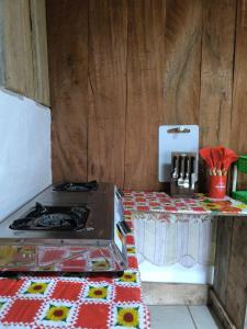 a kitchen with a stove and a counter with a table at Cabaña Cherenga in Sarchí +7 photos