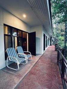 zwei Stühle stehen draußen vor einem Gebäude in der Unterkunft On Cloud Resort in Murree