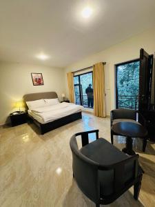 ein Schlafzimmer mit einem Bett und einem Stuhl in der Unterkunft On Cloud Resort in Murree