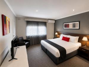 a hotel room with a bed and a chair at Crest on Barkly Hotel in Melbourne +17 photos