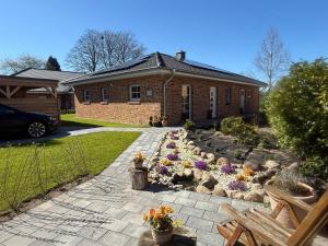 a garden with flowers in front of a house at Grodehus-Eigener-Bungalow in Haby