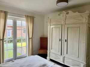 a bedroom with a large white cabinet and a window at Grodehus-Eigener-Bungalow in Haby