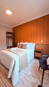 a hotel room with a bed and a chair at Suíte Ipê-Amarelo in Camanducaia