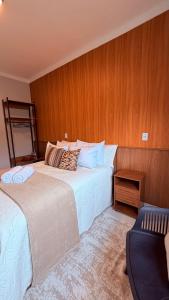 a hotel room with two beds and a chair at Suíte Ipê-Amarelo in Camanducaia
